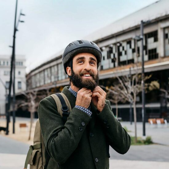 Man i stadsmiljö knäpper sin cykelhjälm, kanske er nästa CFO?